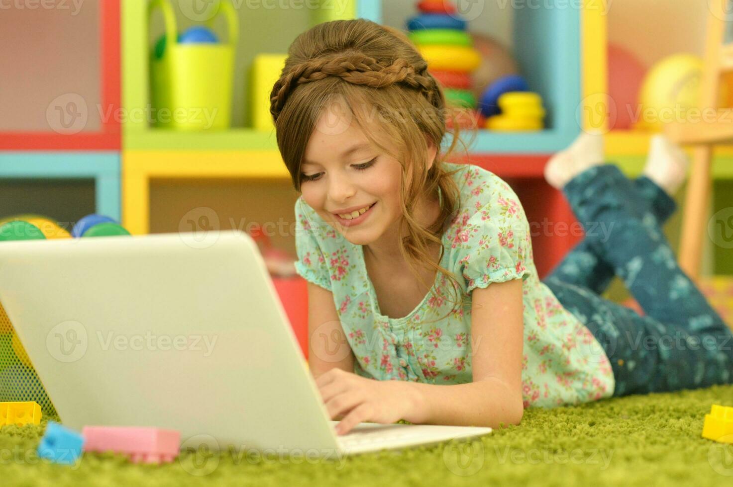 carino e contento poco ragazza bambini utilizzando il computer portatile computer foto