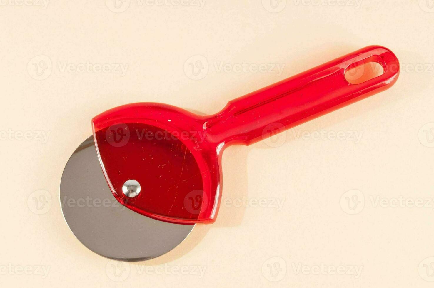 un' rosso plastica coltello con un' maniglia su un' bianca superficie foto