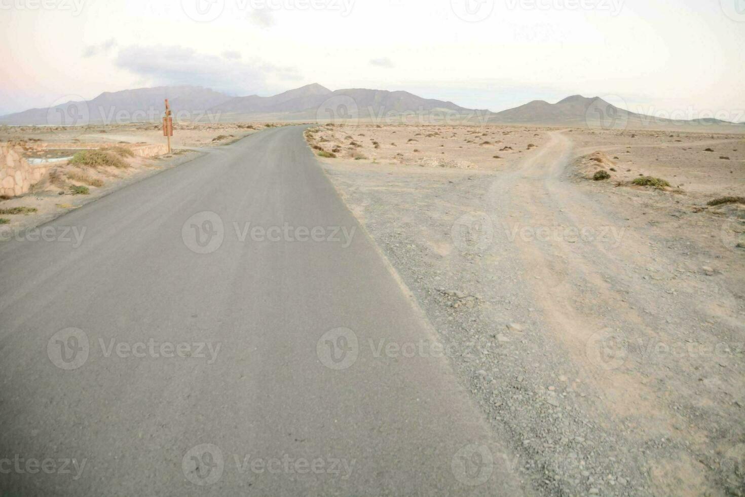 un' strada nel il deserto con montagne nel il sfondo foto