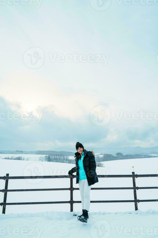 donna turista visitare nel bei, viaggiatore nel maglione giro turistico Visualizza con neve nel inverno stagione. punto di riferimento e popolare per attrazioni nel hokkaido, Giappone. viaggio e vacanza concetto foto