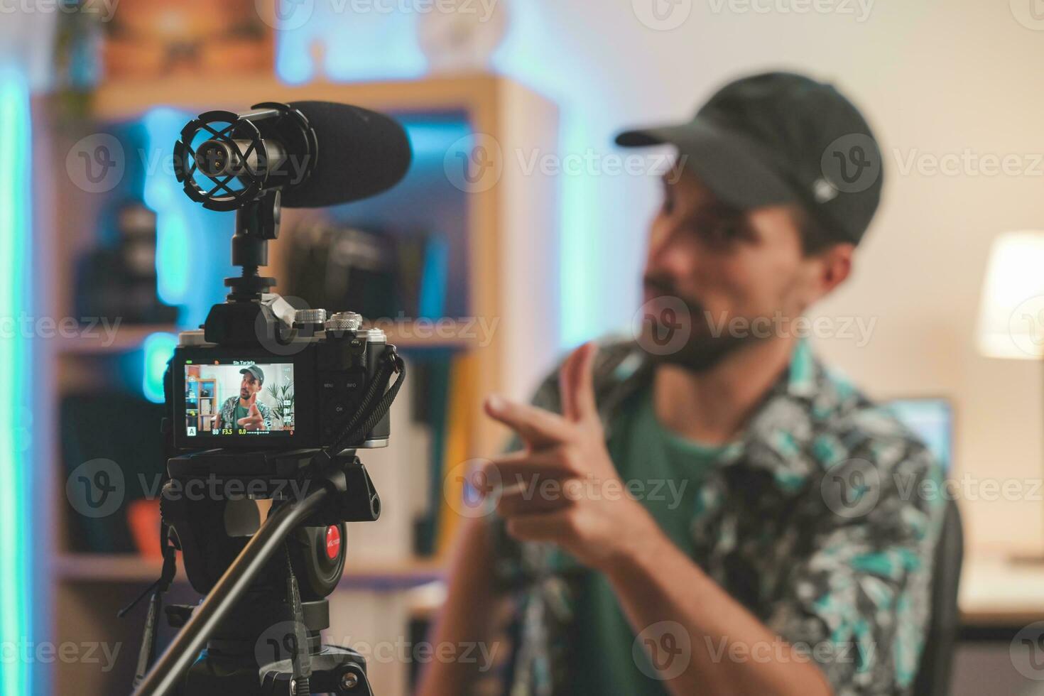 dietro a il scena tiro di un' giovane uomo influencer fabbricazione un' video parlando direttamente per il telecamera foto