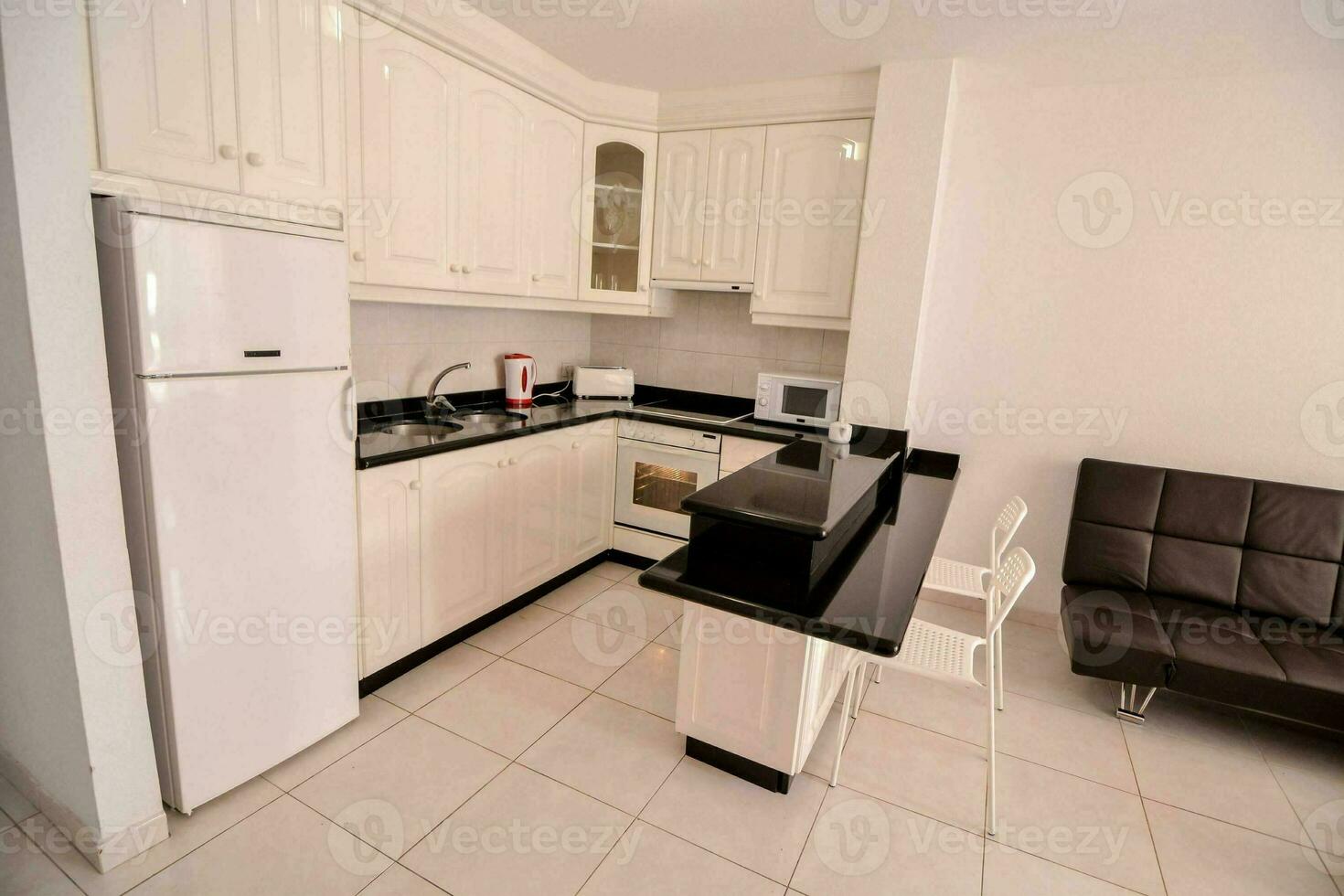 un' cucina con bianca armadietti e nero contatore cime foto
