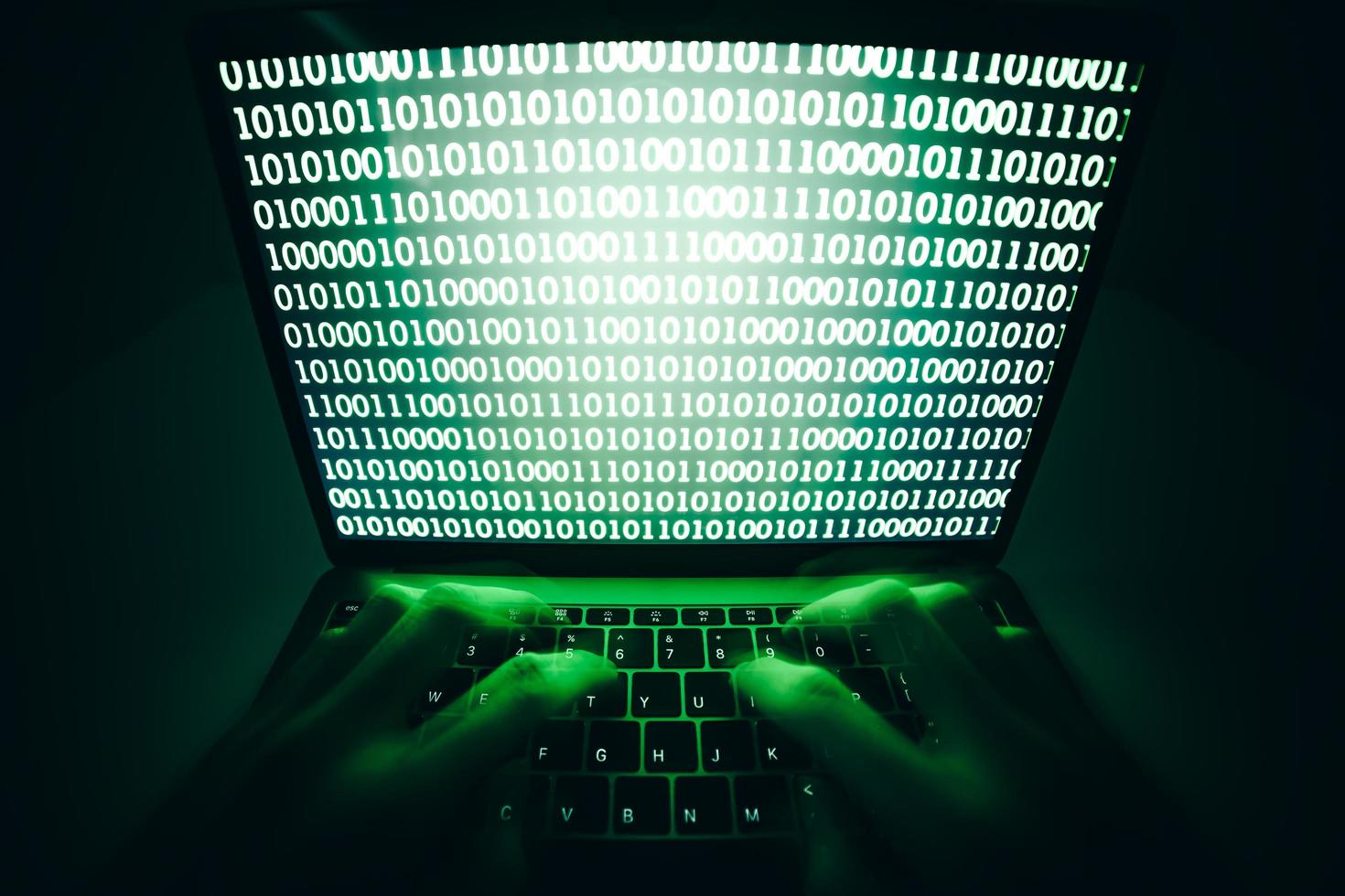 il primo piano dell'hacker sta utilizzando il computer portatile per codificare virus o malware per l'hacking di server Internet, attacco informatico, rottura del sistema, concetto di criminalità su Internet. foto