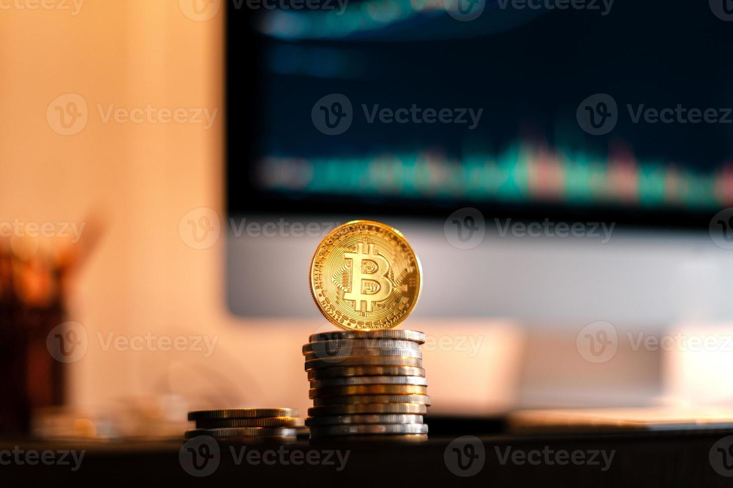 bitcoin è posizionato su una scrivania di fronte a un computer grafico foto