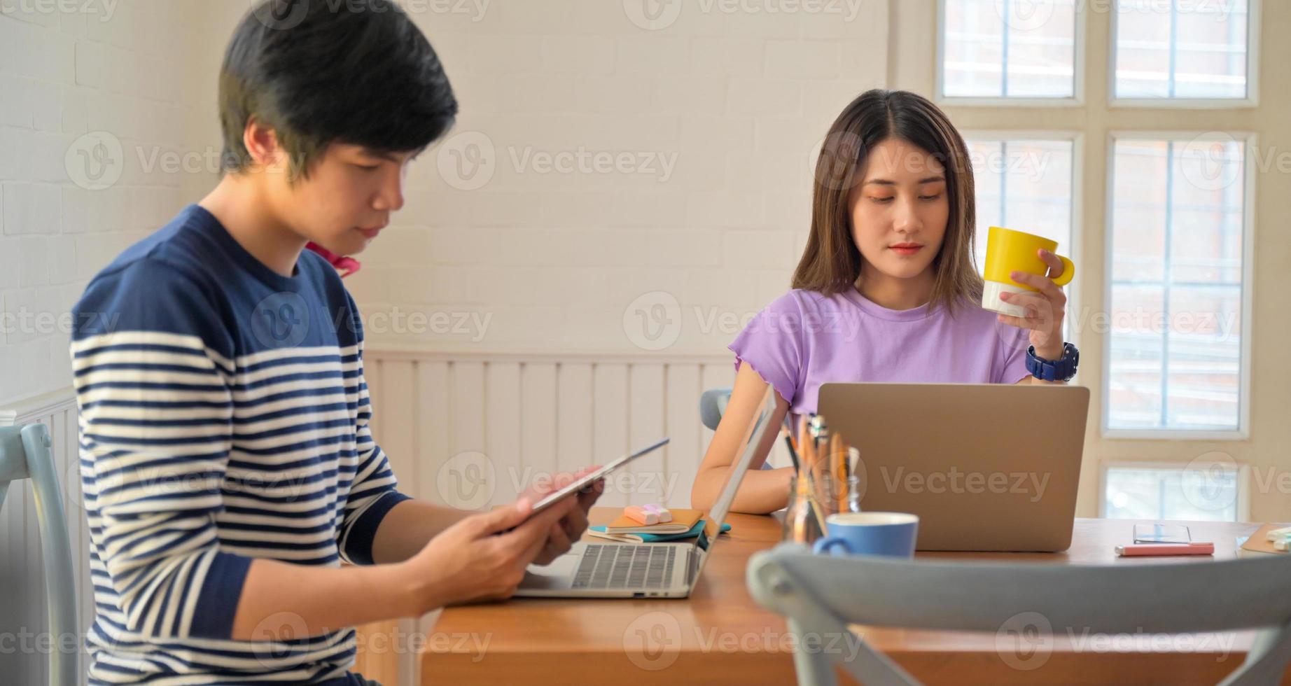 studenti universitari femminili e maschili che tengono tazza da caffè e tablet con pose serie. foto