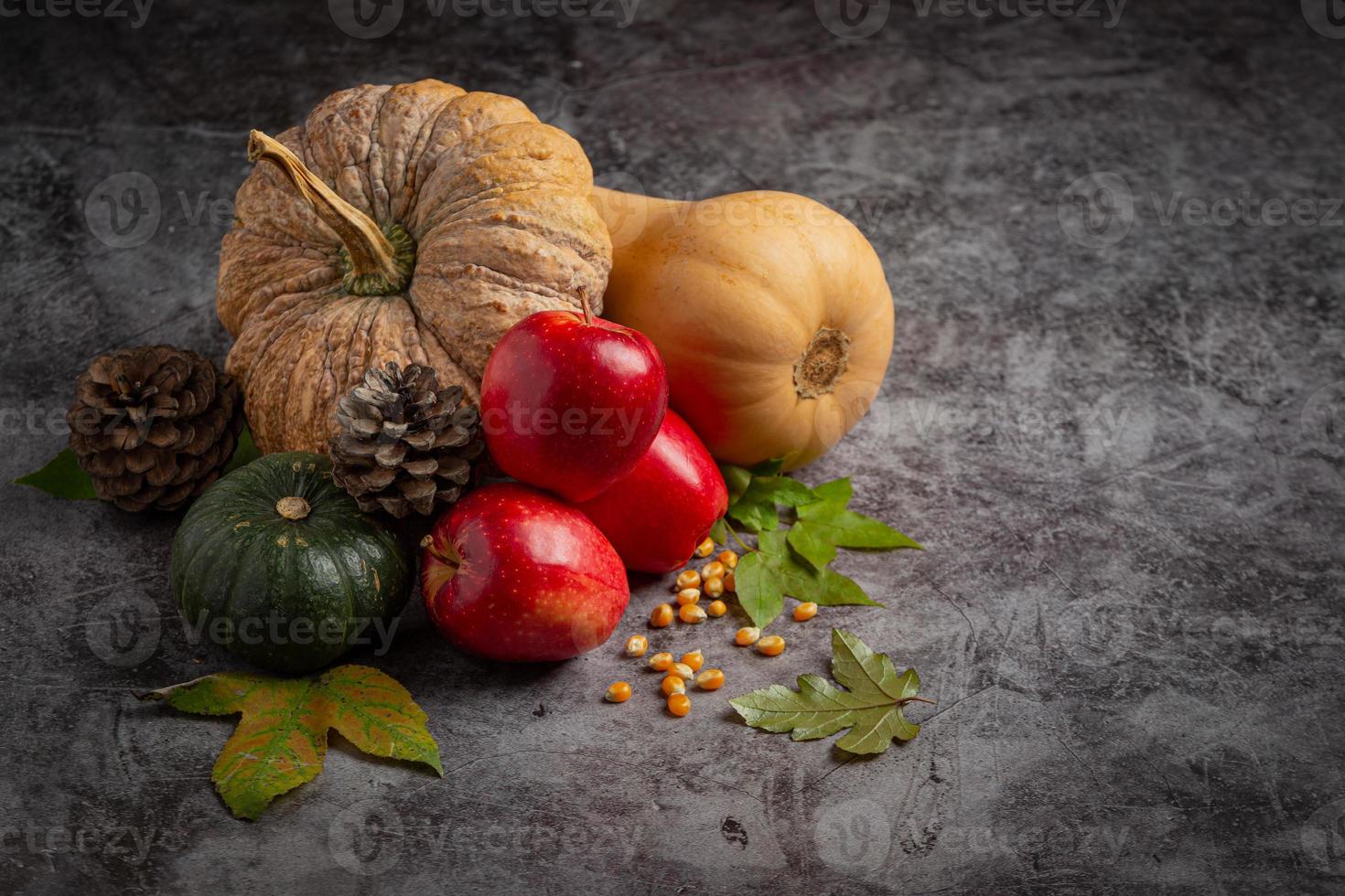 zucca-mela e foglie di acero accatastati su sfondo lavagna concetto. Ciao settembre foto