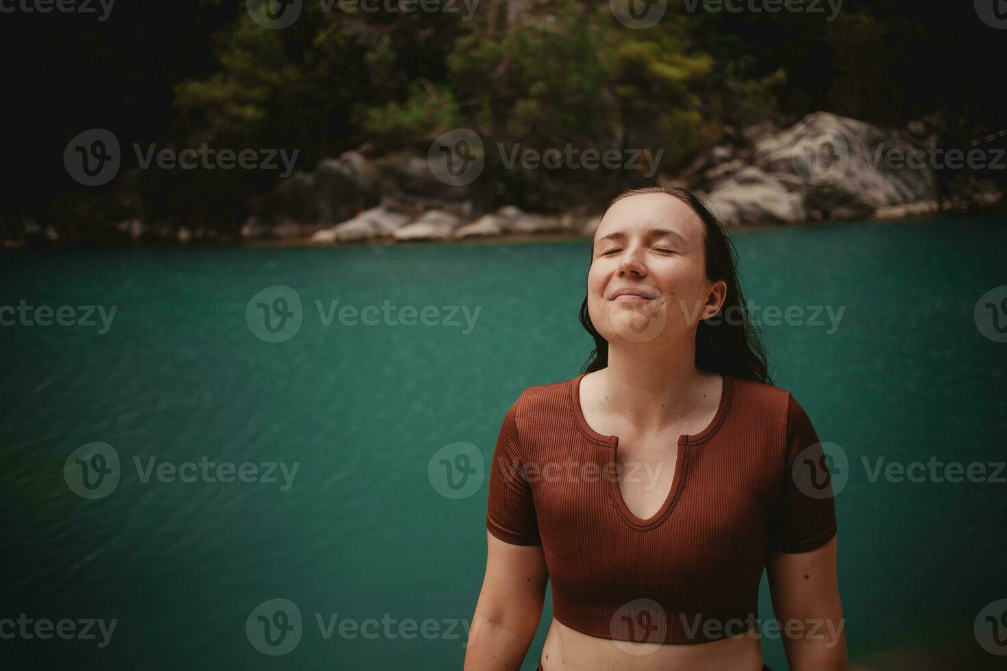 donna godendo la tranquillità su il sfondo di un' lago nel tacchino sorridente foto