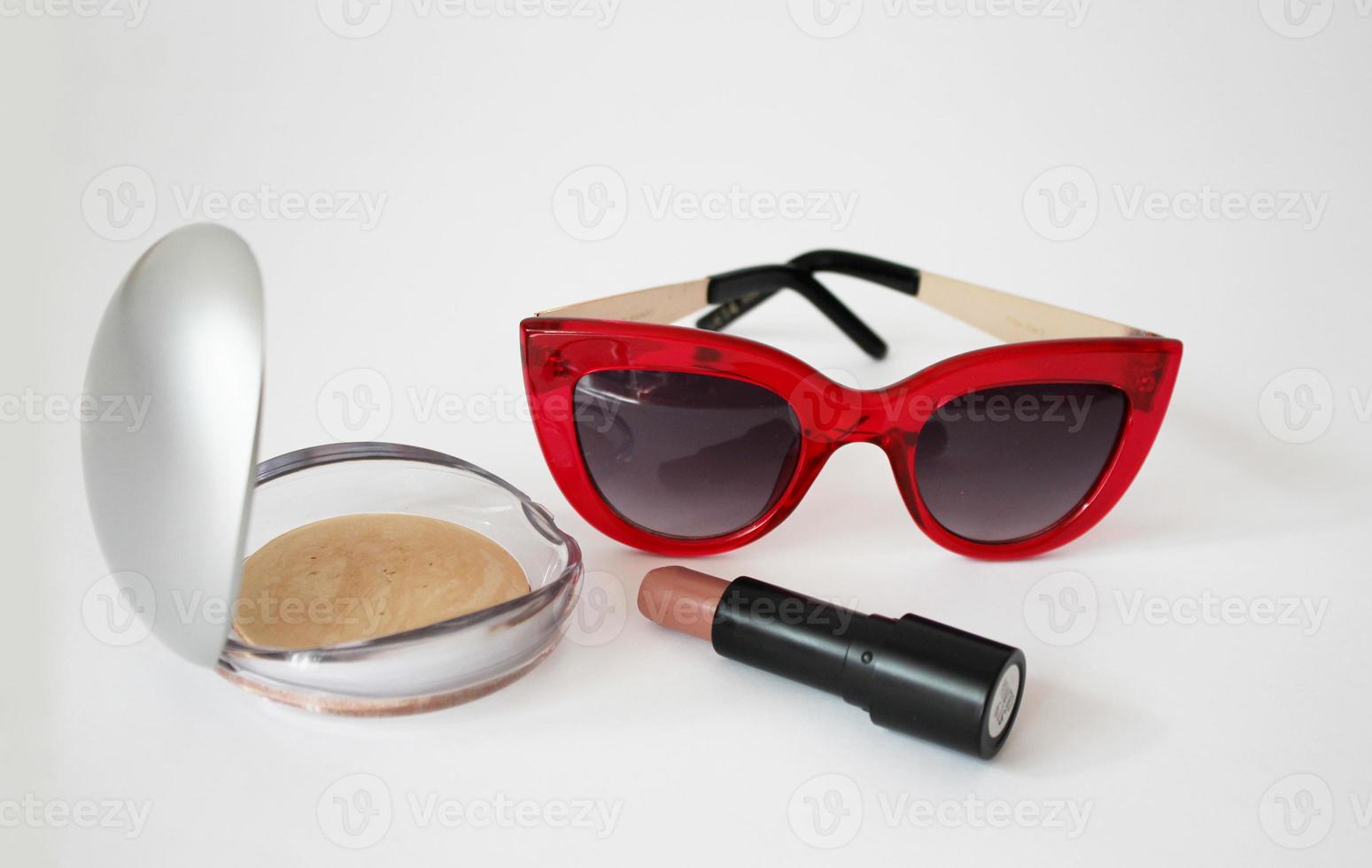 cosmetici da donna e occhiali da sole rossi foto