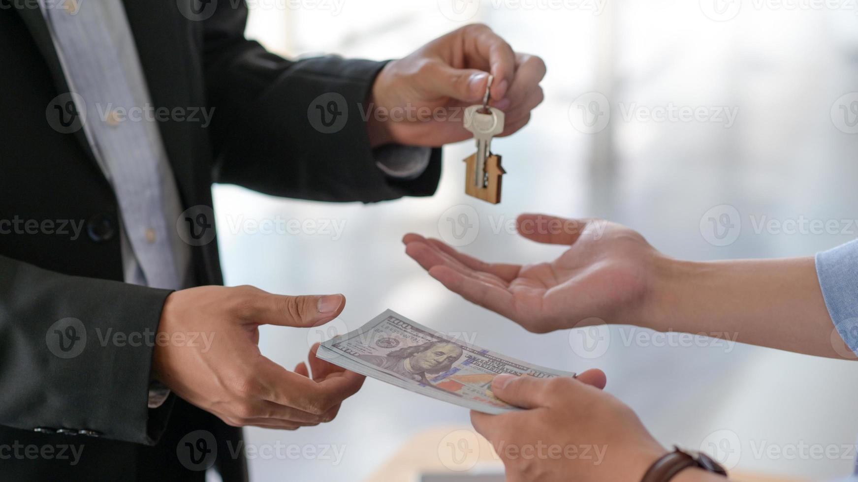 colpo ritagliato di scambio di dollari e chiavi di casa tra acquirente e venditore. foto