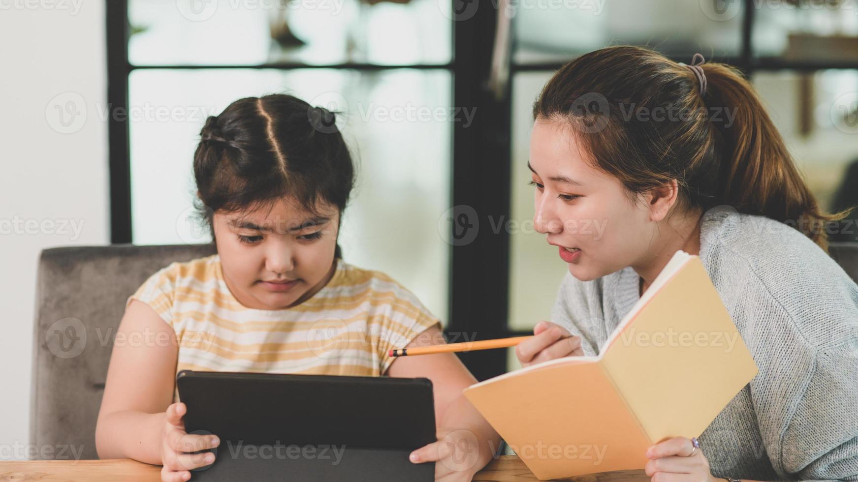 tutor che insegna i compiti alle bambine. foto