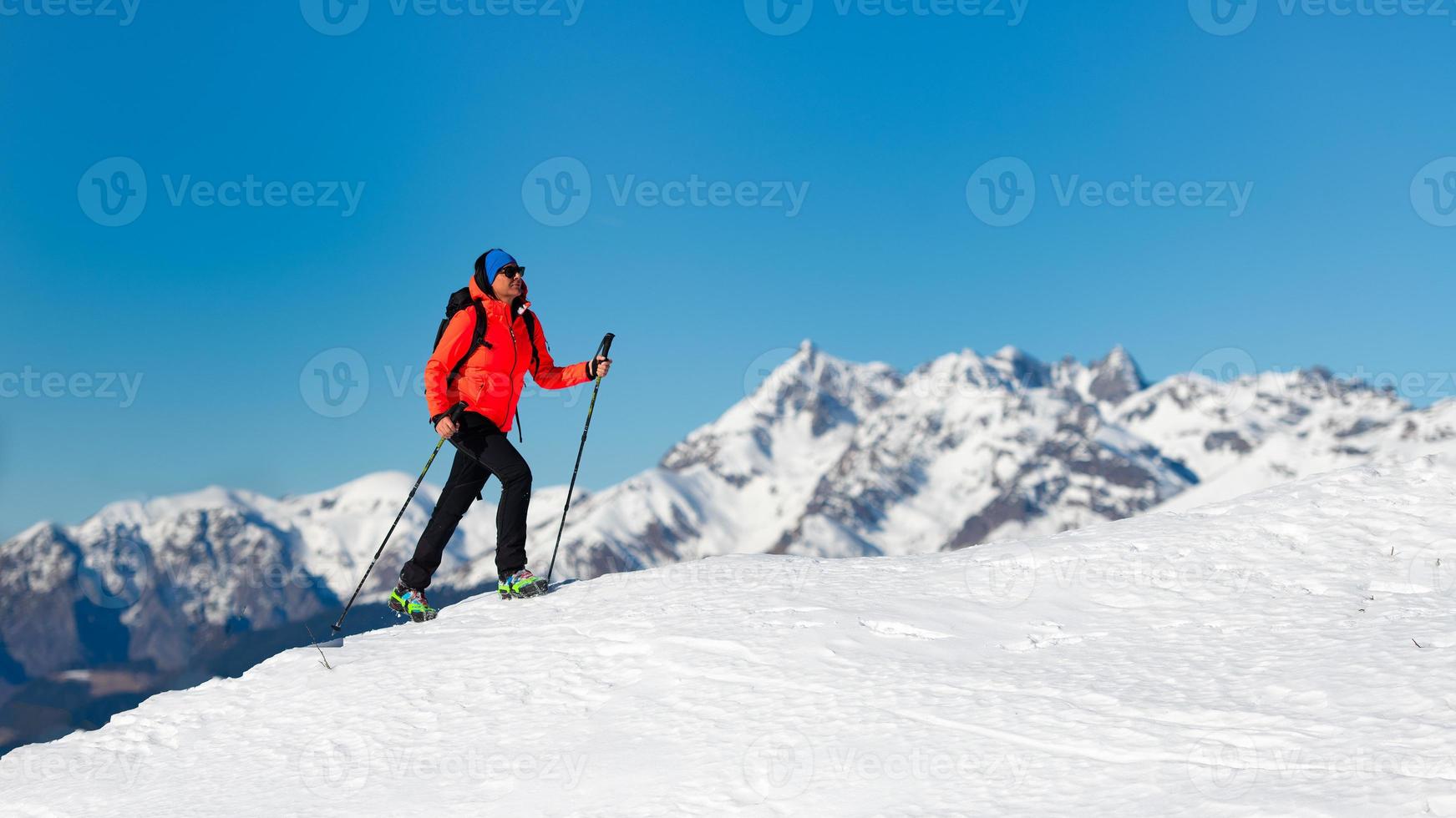 una donna sola cammina sulla neve con i ramponi foto