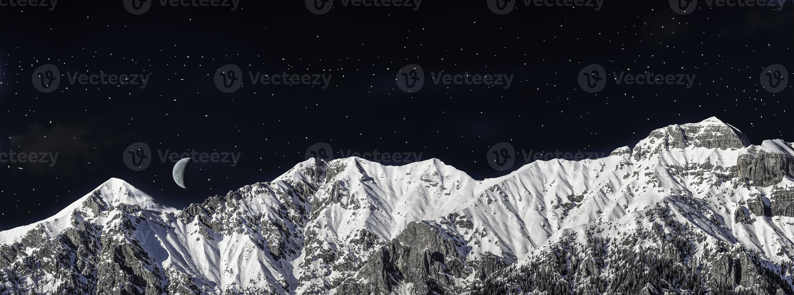 catena di montagne in inverno nella notte foto