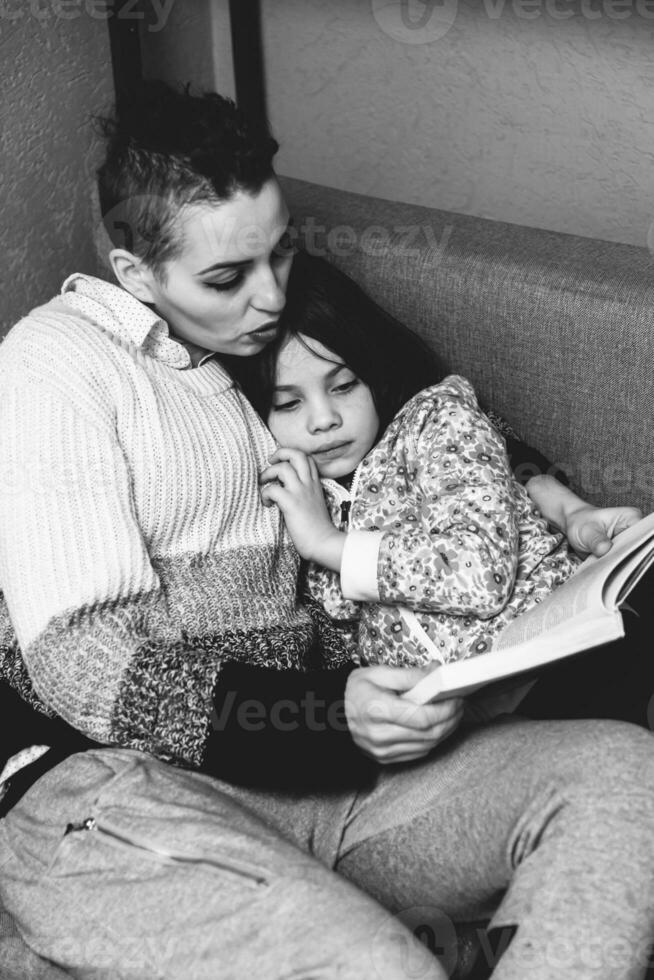 mamme figlia lettura un' libro dire bugie su il divano foto