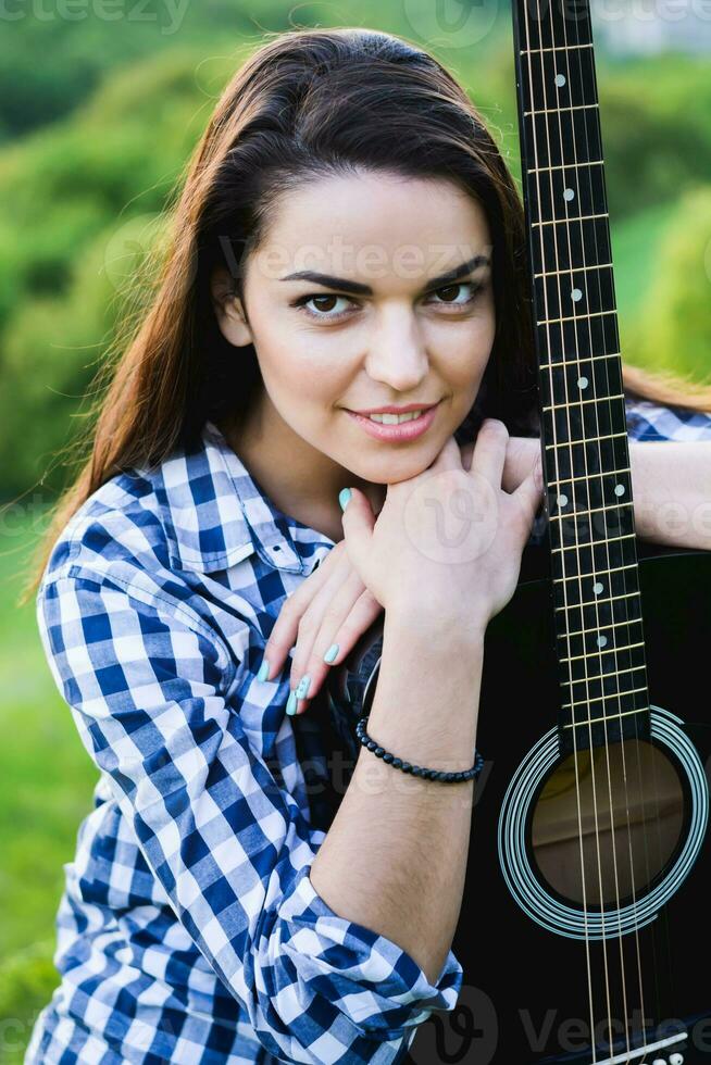 ragazza su un' verde prato giocando chitarra foto