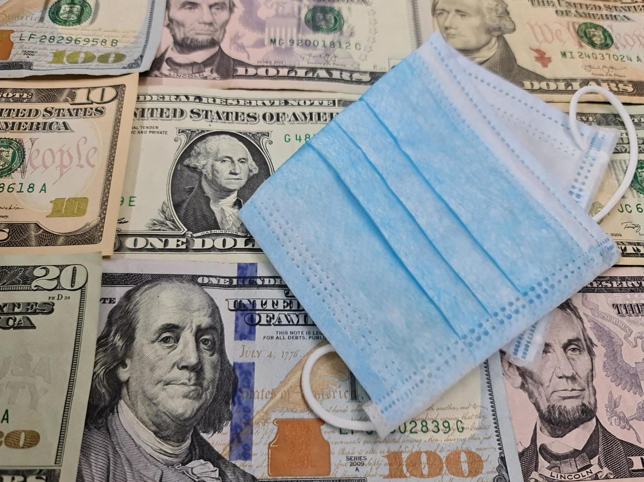 maschera usa e getta sullo sfondo con banconote da un dollaro americano foto