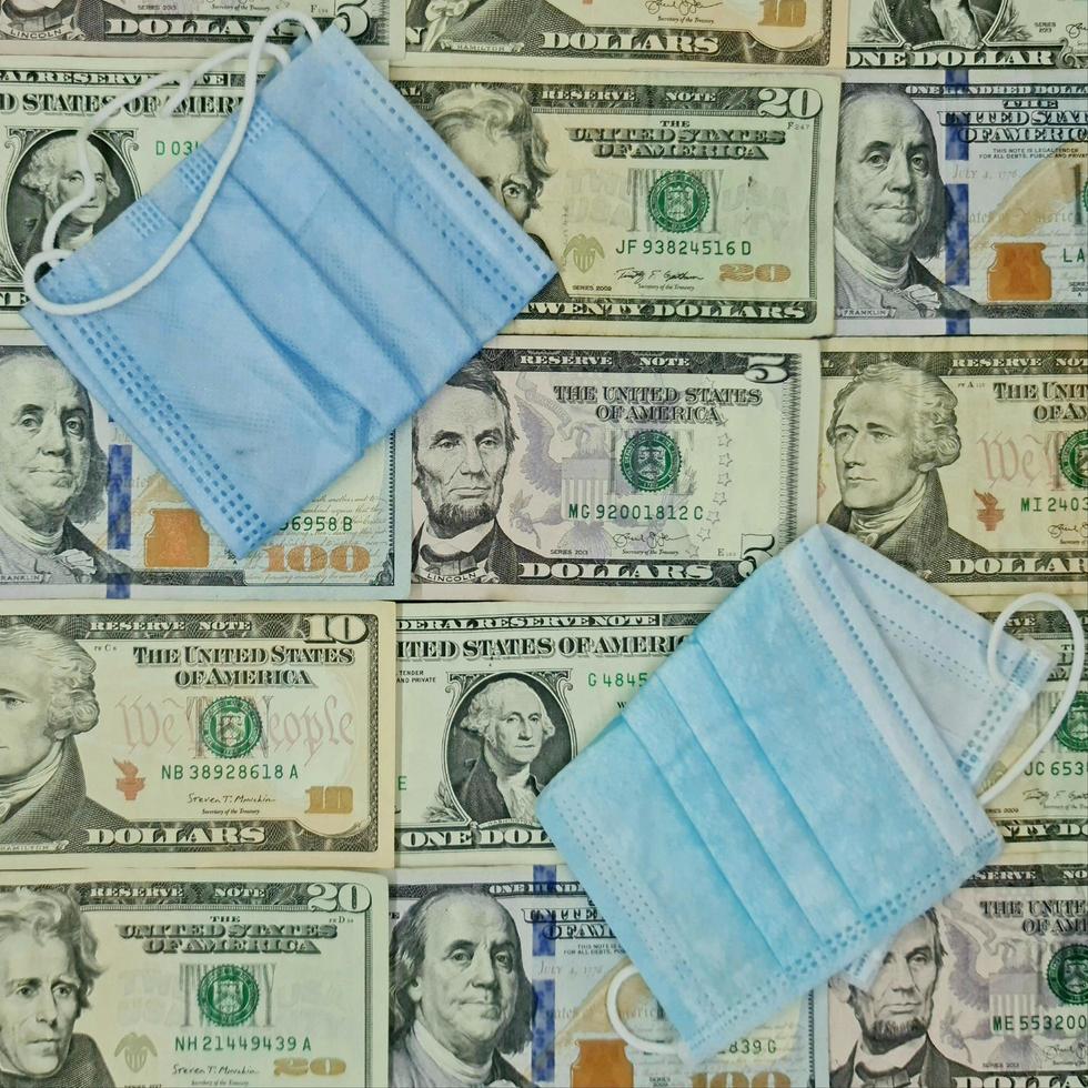 maschere facciali usa e getta e sfondo con banconote da un dollaro americano, vista dall'alto foto