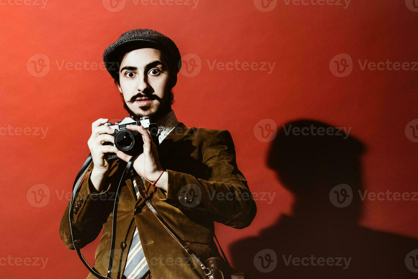 molto positivo fotografo in posa nel studio con film telecamera foto