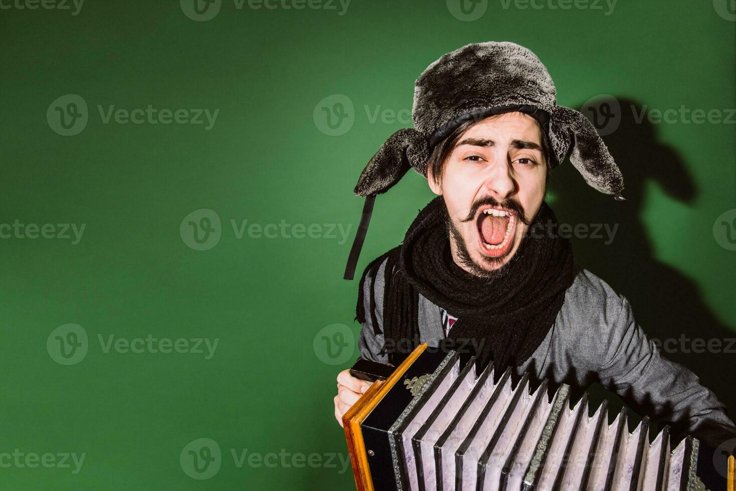 un' molto positivo uomo con un fisarmonica in posa nel il studio foto