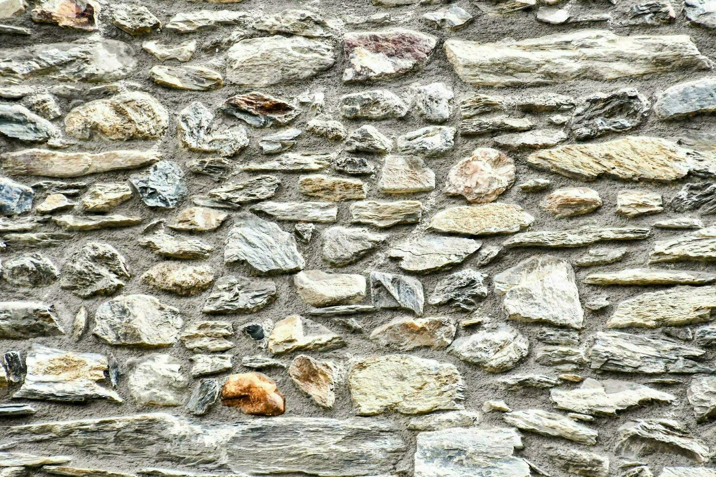 un' parete fatto di pietra con molti diverso tipi di rocce foto