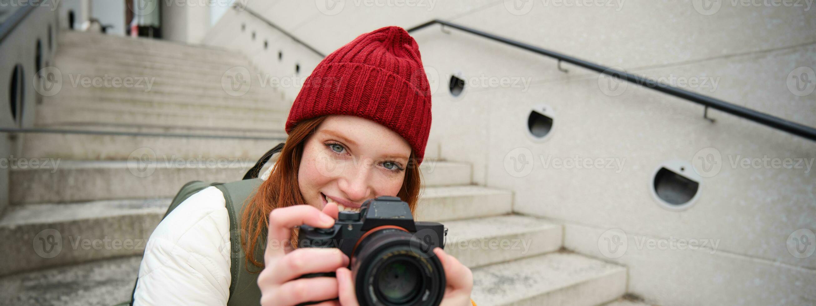 ritratto di femmina fotografo a piedi in giro città con professionale telecamera, assunzione immagini cattura urbano colpi, Fotografare all'aperto foto