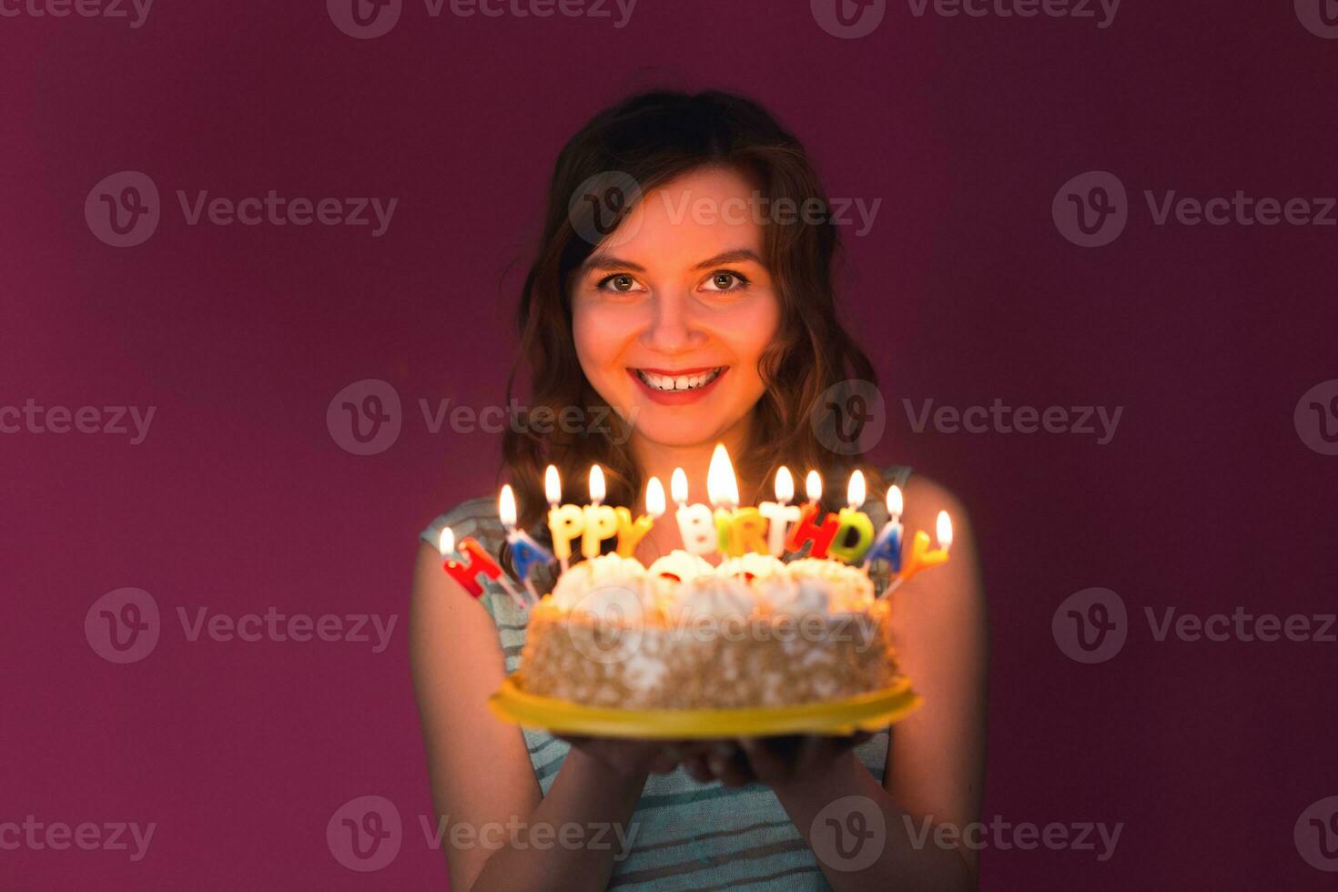 ritratto di gioioso ragazza Tenere compleanno torta e guardare a telecamera a studio foto