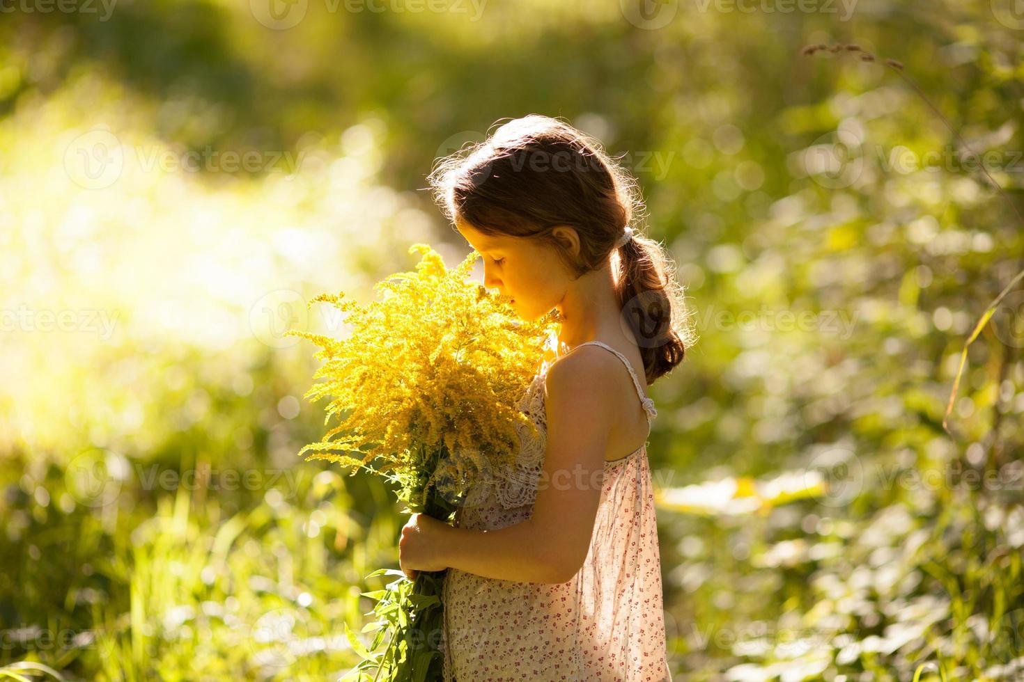 bambina in piedi con un bouquet foto