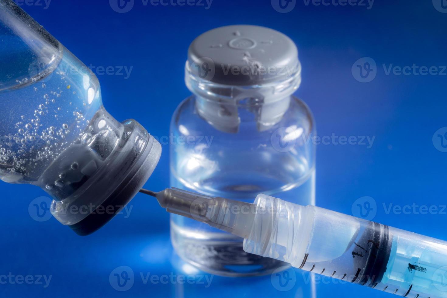 produzione in studio di siringhe e fiale per vaccino su sfondo blu, in brasile foto