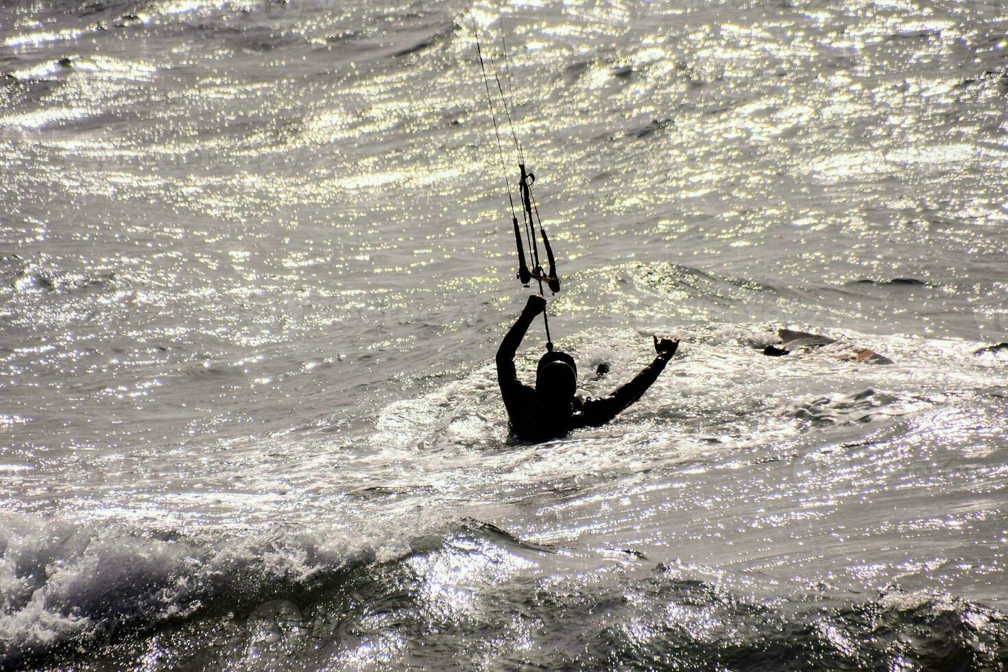 un' uomo kiteboarding nel il oceano a tramonto foto