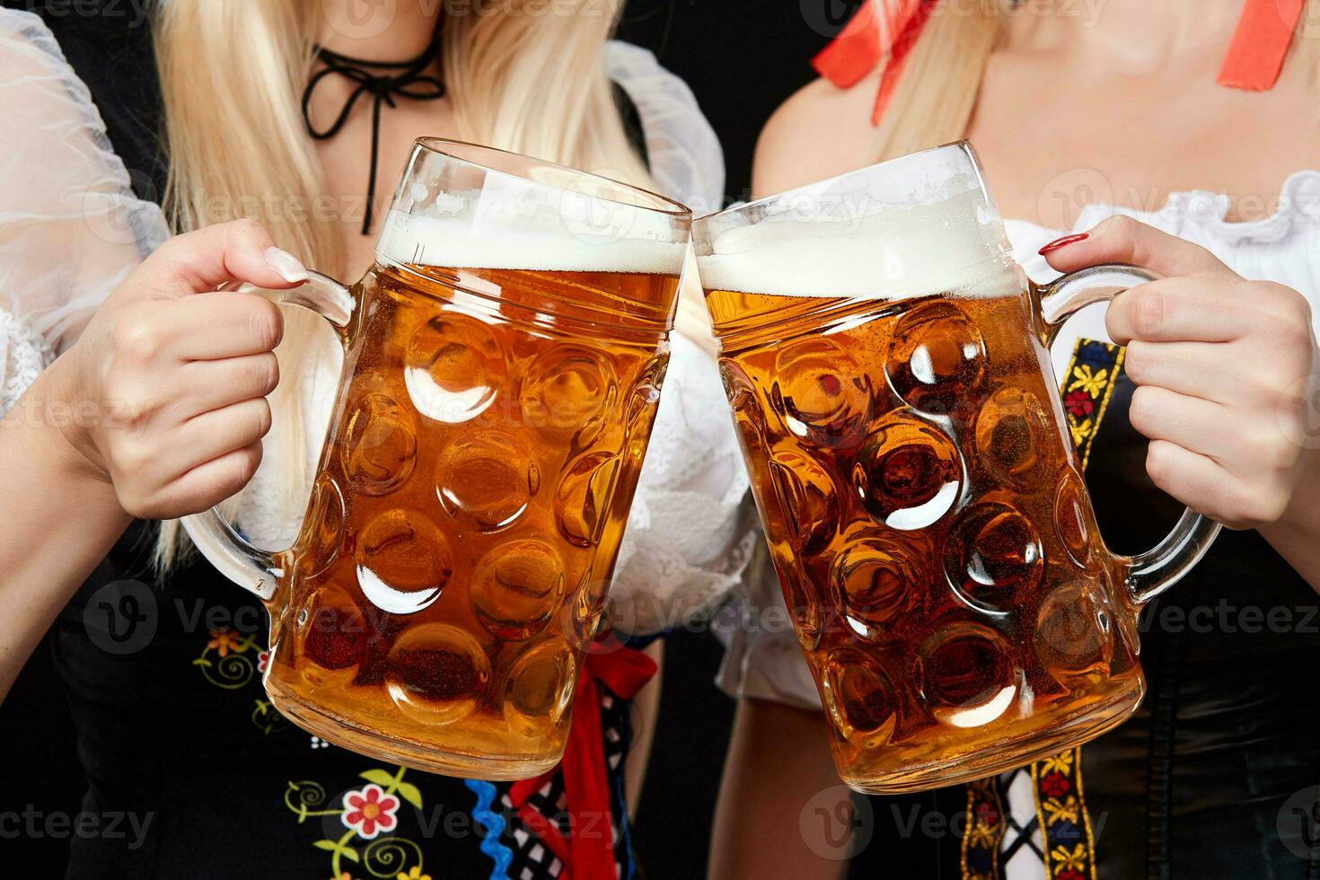 giovane e bellissimo bavarese ragazze con Due birra tazze su nero sfondo foto