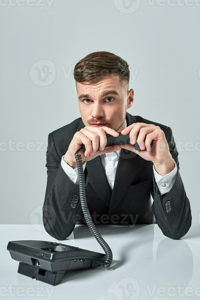 giovane uomo quadranti il Telefono numero mentre seduta nel il ufficio foto