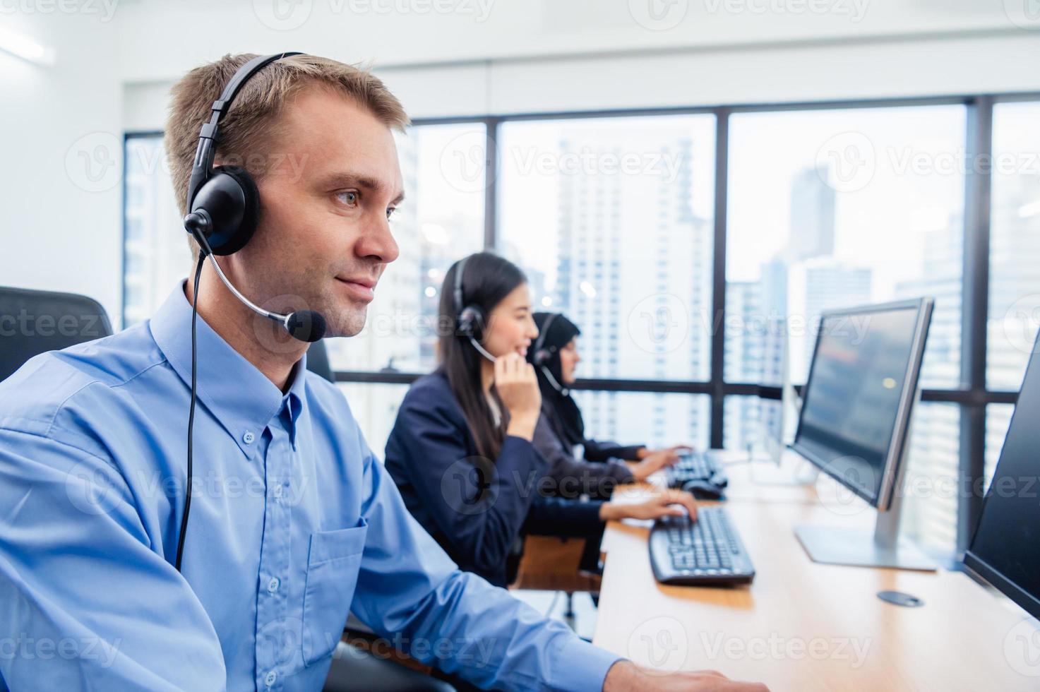 gruppo di agente operatore di call center di giovane professione con cuffie che lavorano in ufficio. persone del servizio di telemarketing aziendale che si concentrano sul lavoro di conversazione e parlano con il cliente amichevole foto