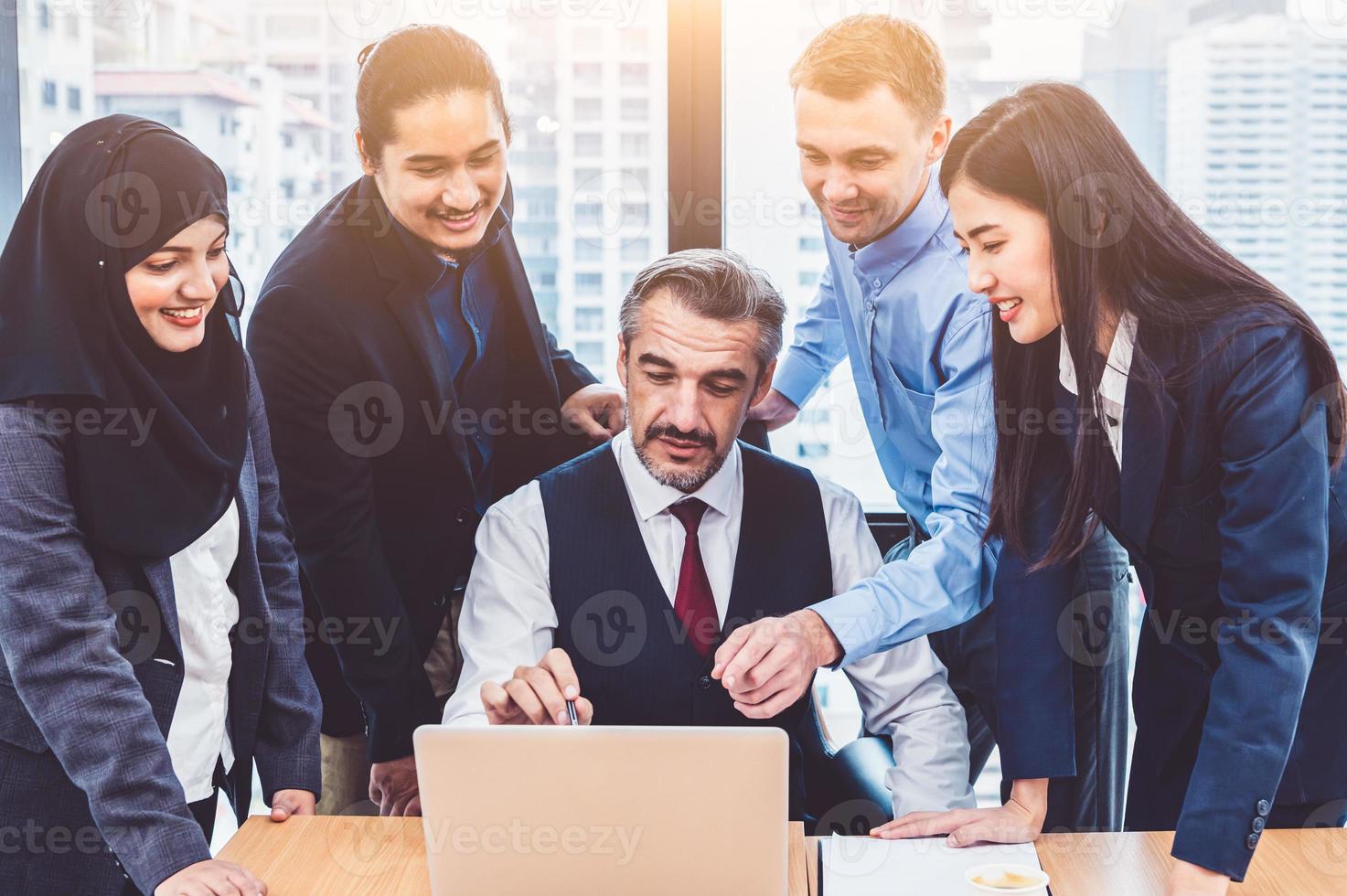 gruppo di uomini d'affari multietnici che si addestrano dal capo senior esecutivo in un ufficio moderno con un computer portatile. riunione del team di avvio e brainstorming, persone che lavorano con un concetto di workshop per conferenze foto