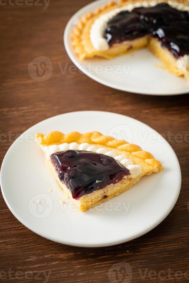 torta di formaggio ai mirtilli su piatto bianco foto