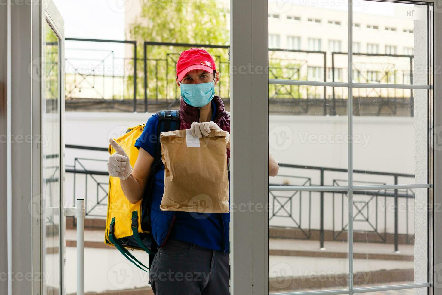 consegna uomo in piedi con giallo termo zaino per cibo consegna vicino il Ingresso casa con vuoto spazio per copia incolla foto