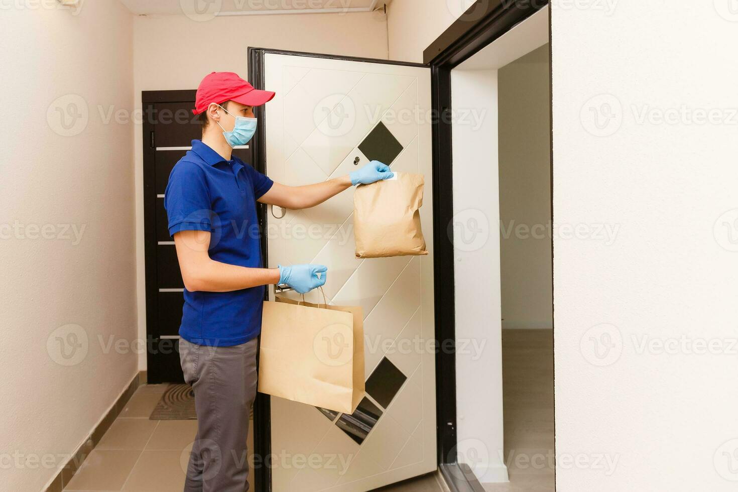 Corriere nel protettivo maschera e medico guanti consegna porta via cibo. consegna servizio sotto quarantena, malattia scoppio, coronavirus covid-19 pandemia condizioni. foto