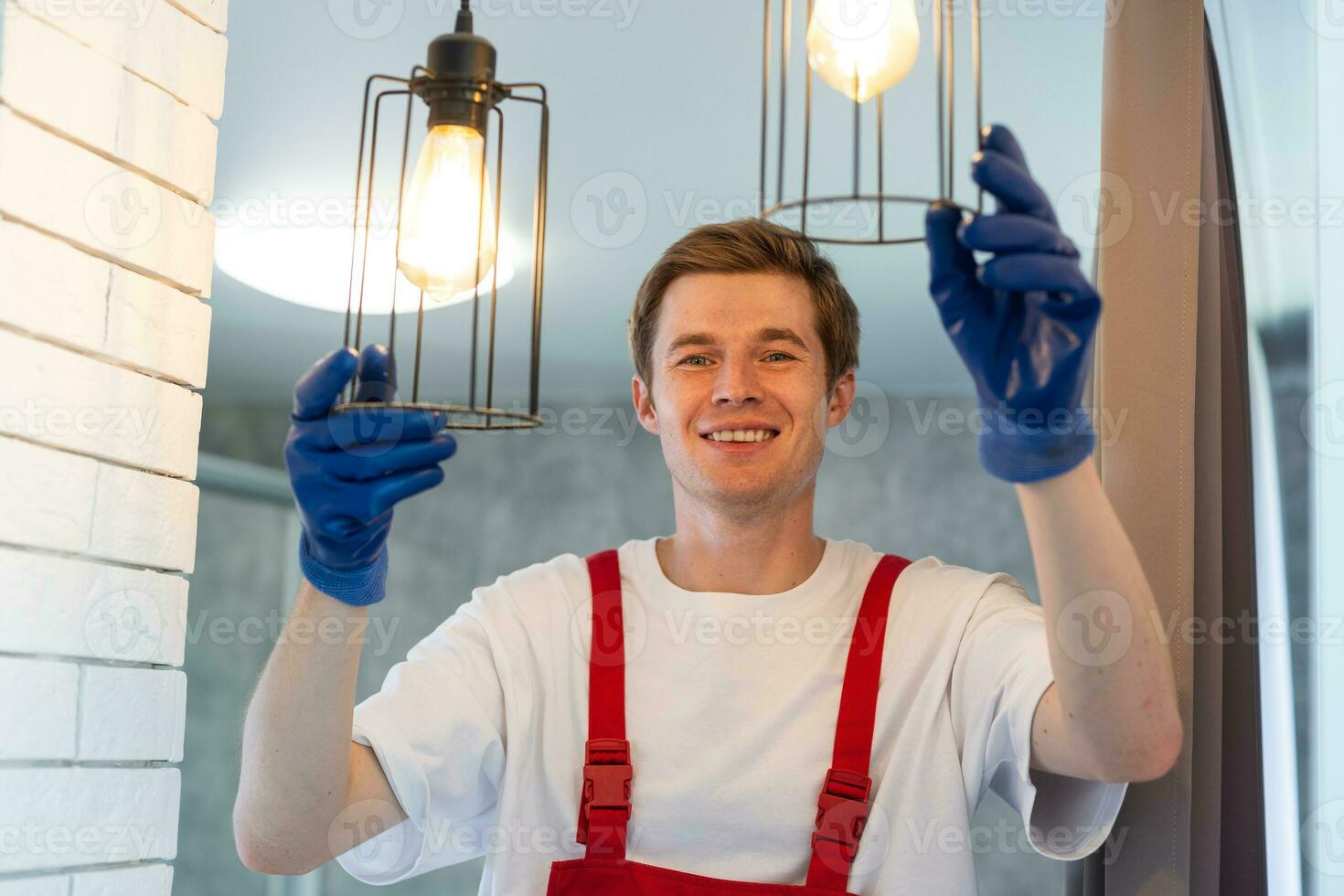 giovane uomo installazione soffitto lampada su scaletta nel cucina foto