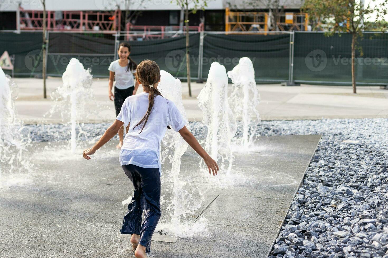 su un' caldo giorno, bambini correre e avere divertimento a il città Fontana. tempo libero tempo concetto. estate vacanze. contento infanzia. foto