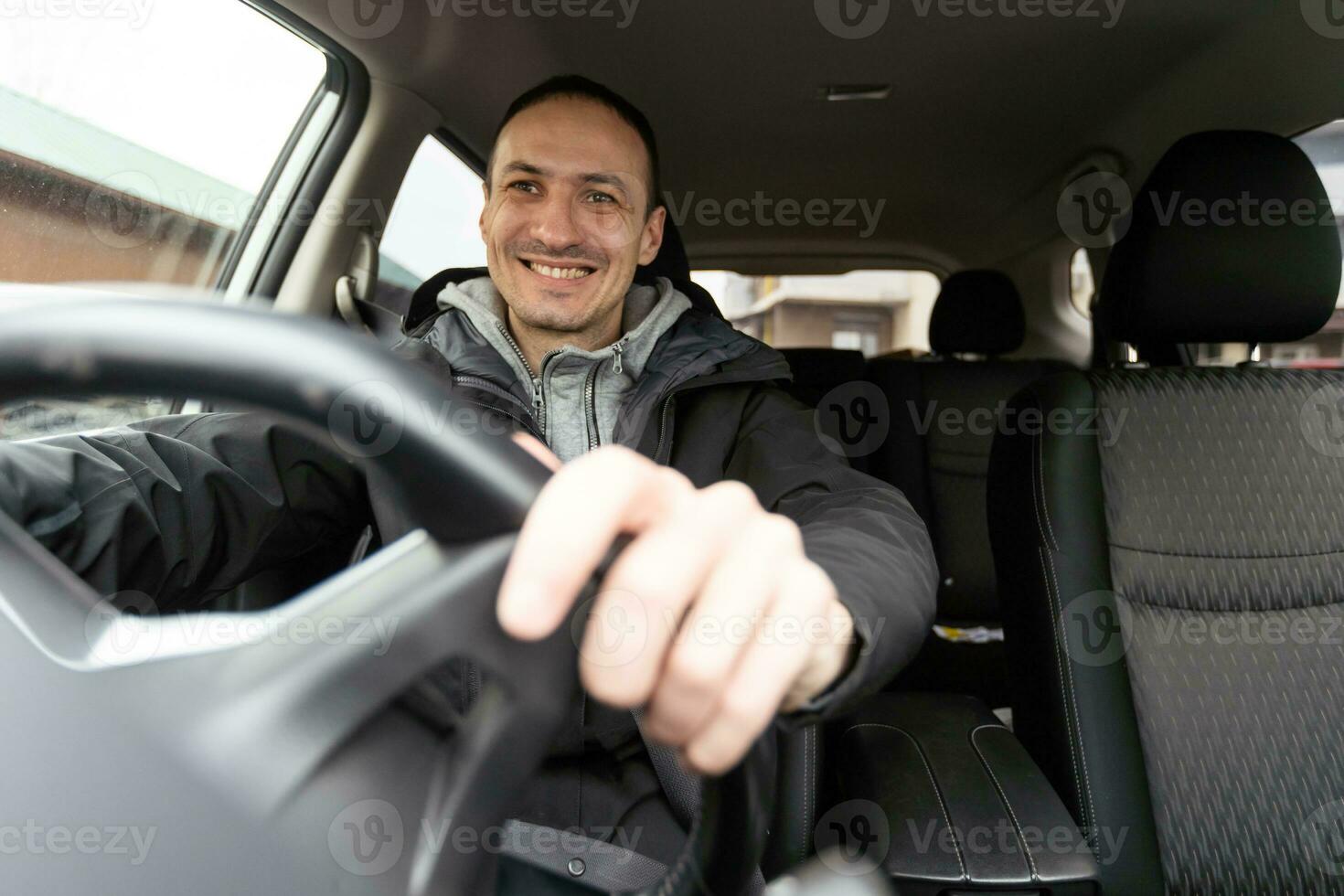 mio bambino. tiro di un' contento uomo seduta nel il suo auto toccante il pannello di controllo delicatamente sorridente allegramente foto