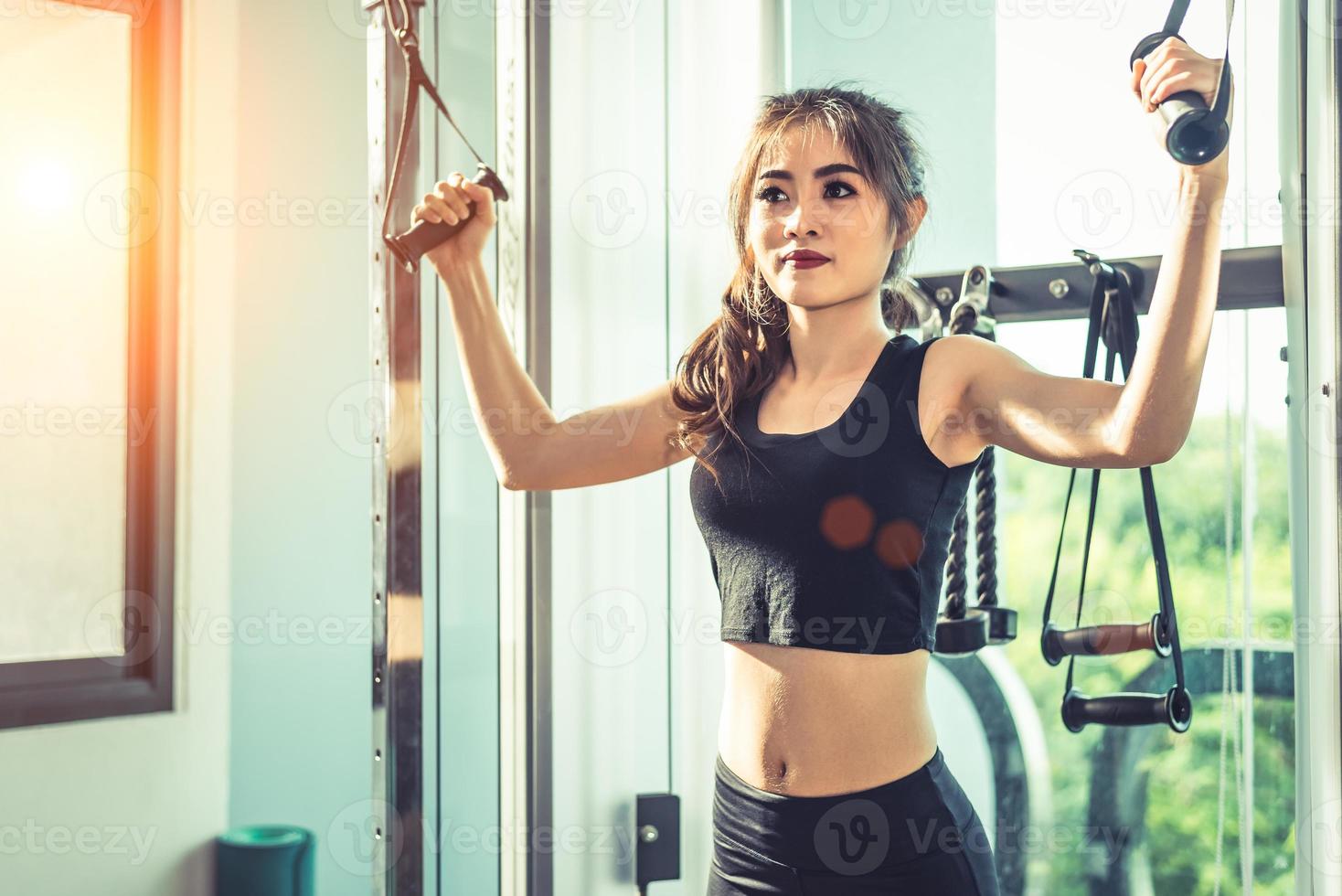 giovane donna asiatica che fa esercizi di corda elastica in palestra cross fitness. allenamento della forza e bellezza muscolare e concetto sano. attrezzatura sportiva e tema del centro del club sportivo foto