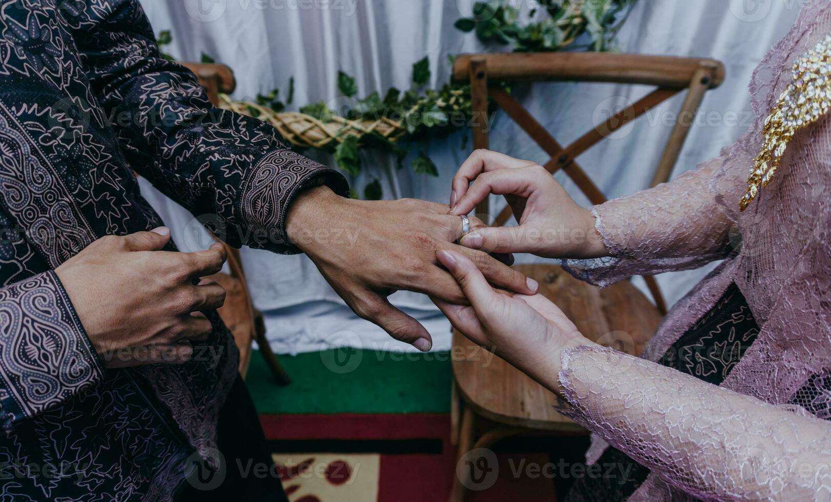 sposa mette un' squillare su il sposo dito. cerimonia e nozze pianificazione. oro anelli per musulmano spose nel Indonesia. Fidanzamento momento. foto