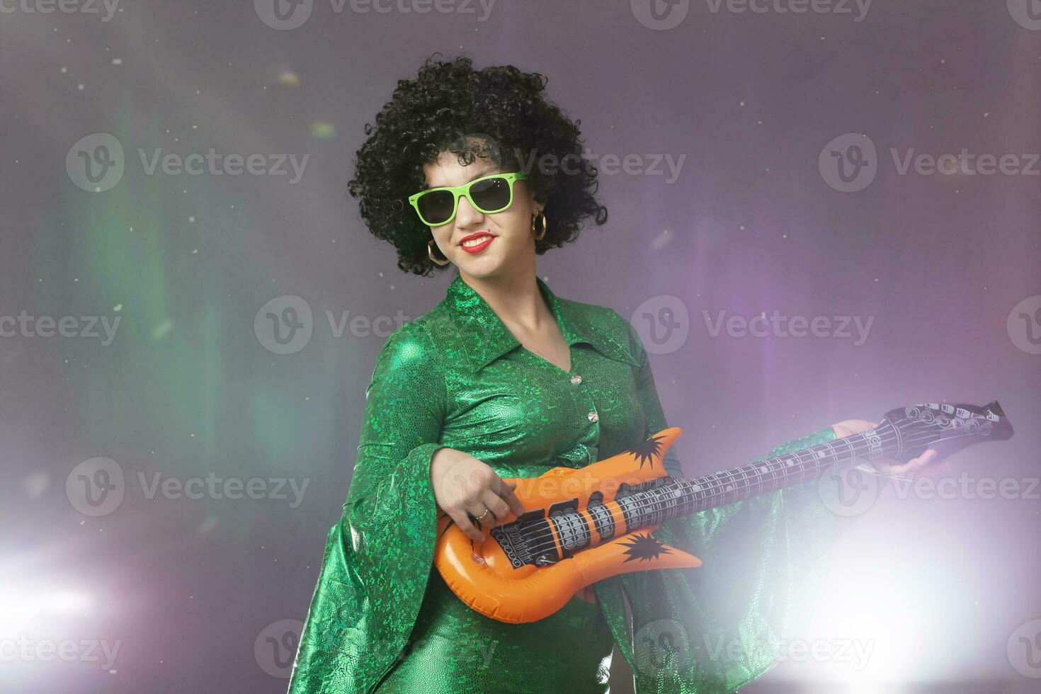 divertente pop ragazza con un' giocattolo chitarra. donna nel anni ottanta discoteca costume. foto