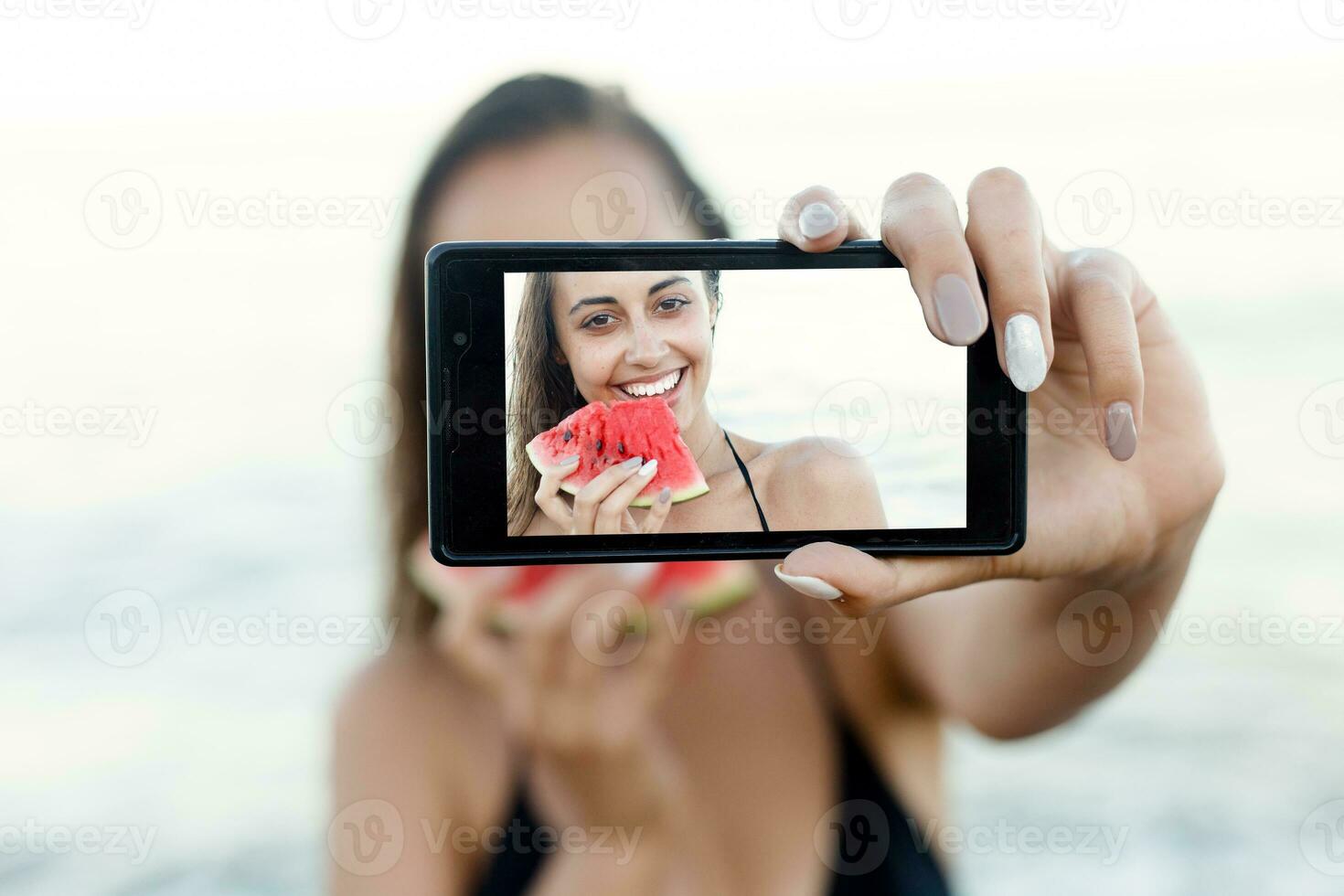 estate vacanza - giovane ragazza mangiare fresco anguria su sabbioso spiaggia foto