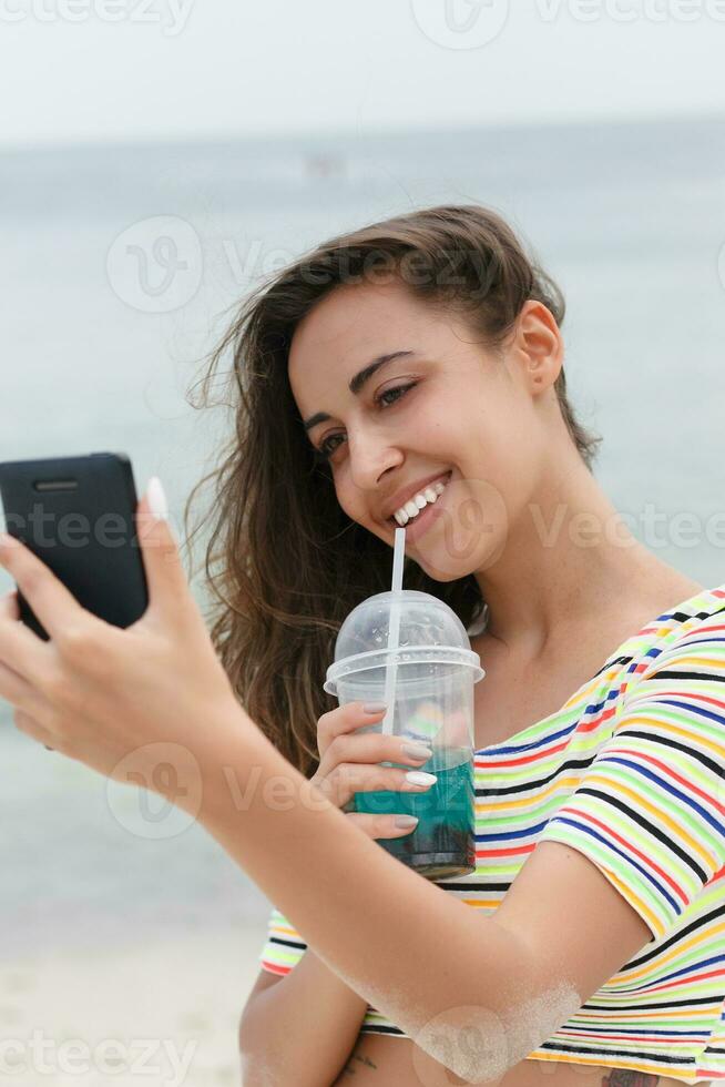 spiaggia donna potabile freddo bevanda bevanda avendo divertimento a spiaggia festa. foto