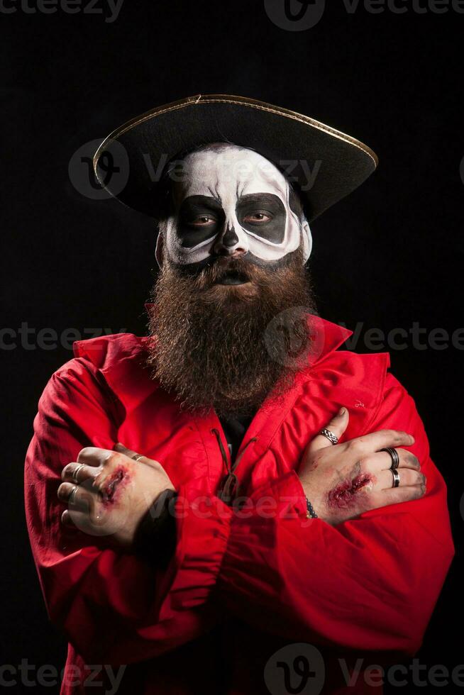 spaventoso barbuto uomo con pirata attrezzatura per Halloween guardare a il telecamera al di sopra di nero sfondo. foto