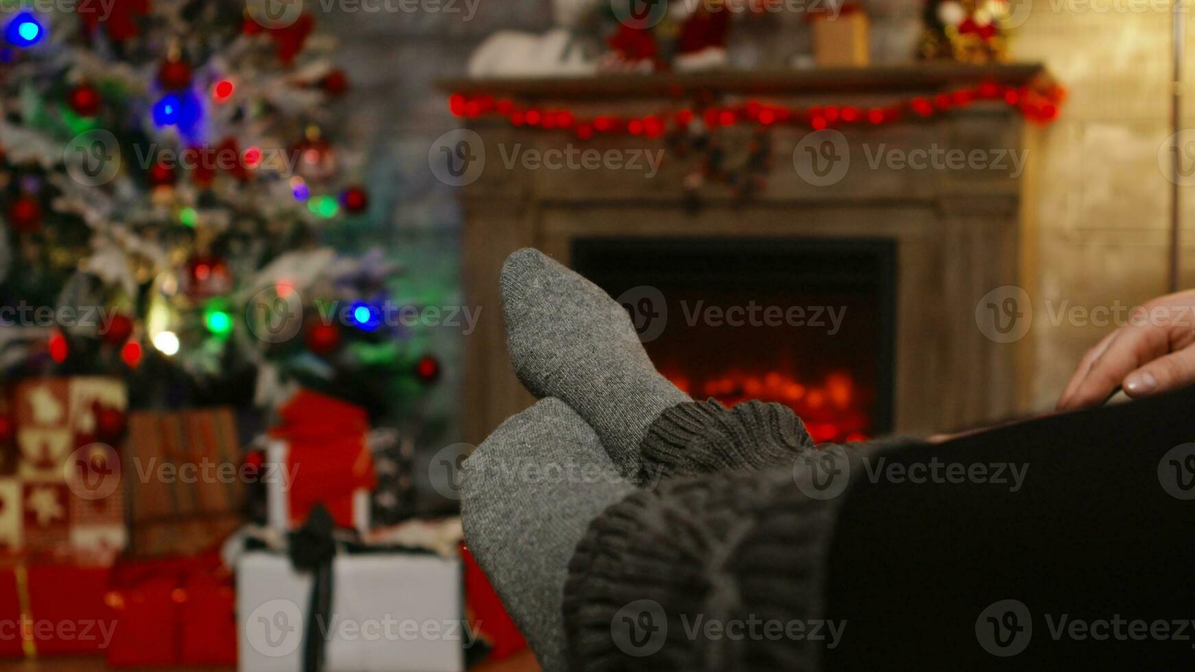 vicino su di donna piedi rilassante su fidanzato ginocchia su Natale giorno seduta su divano. Natale coppia Magia accogliente caldo il camino, la spesa festivo vacanze insieme nel famiglia foto