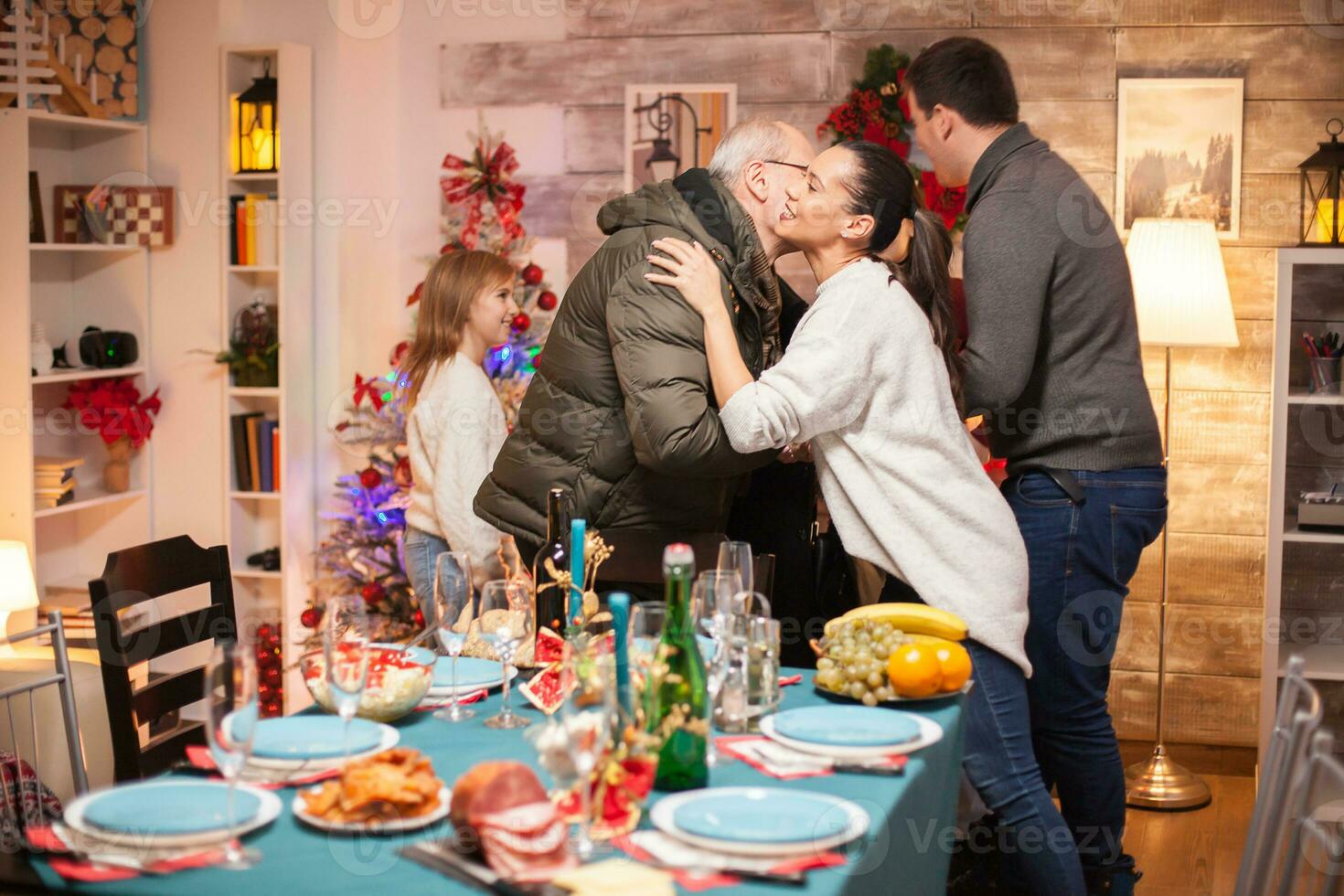 contento donna saluto sua padre nel legge per Natale famiglia cena. foto