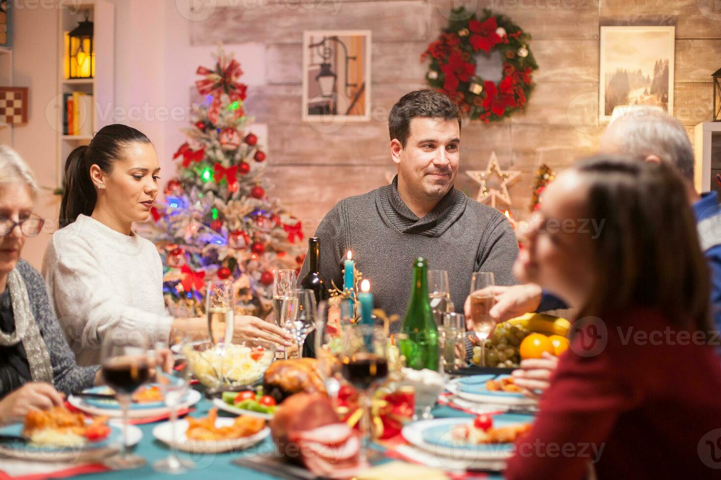 contento giovane uomo a Natale famiglia cena guardare a il suo padre. foto