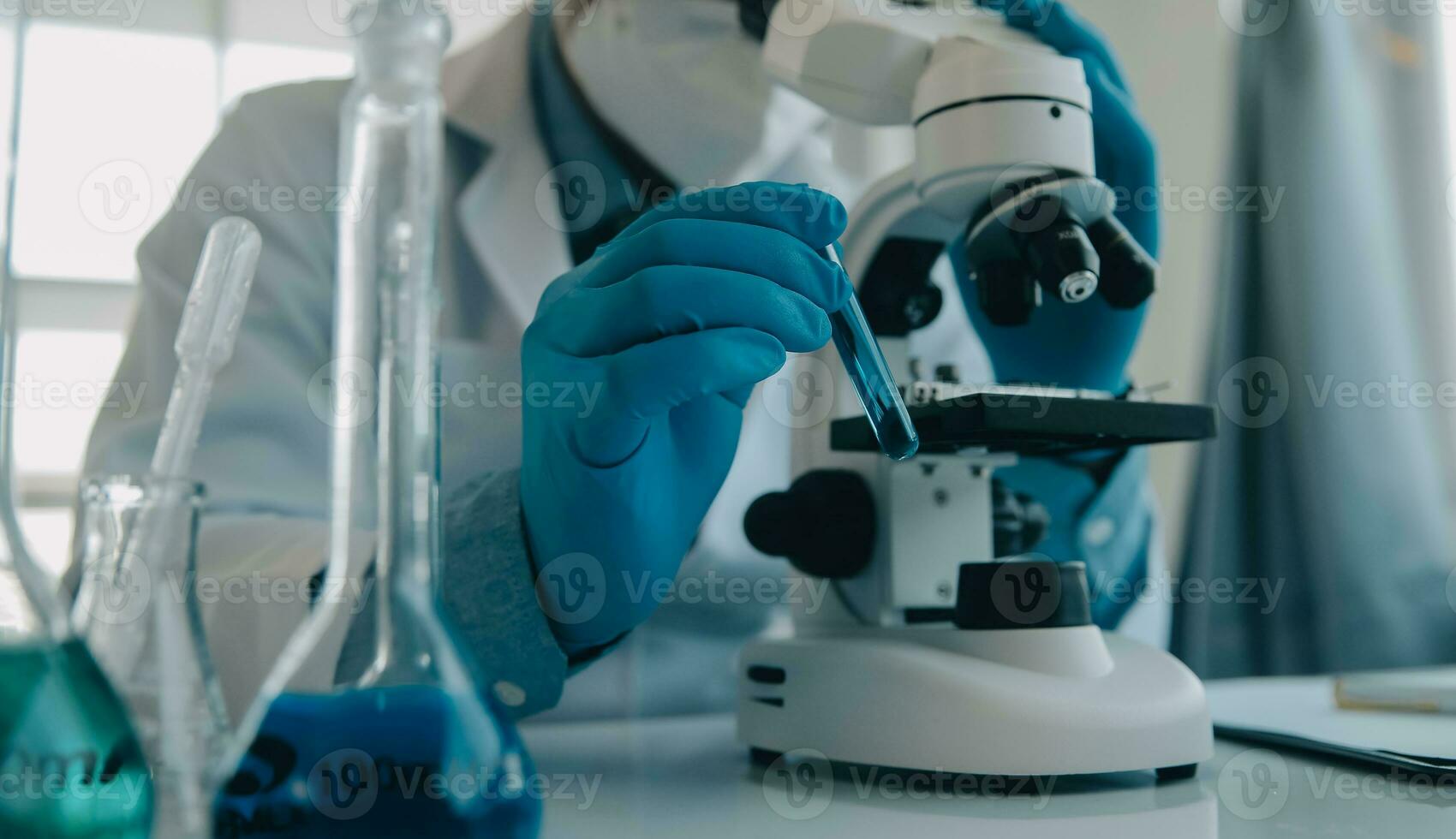 team di ricercatori biochimici che lavora con il microscopio per lo sviluppo del vaccino contro il coronavirus nella ricerca farmaceutica labolatoria, messa a fuoco selettiva foto