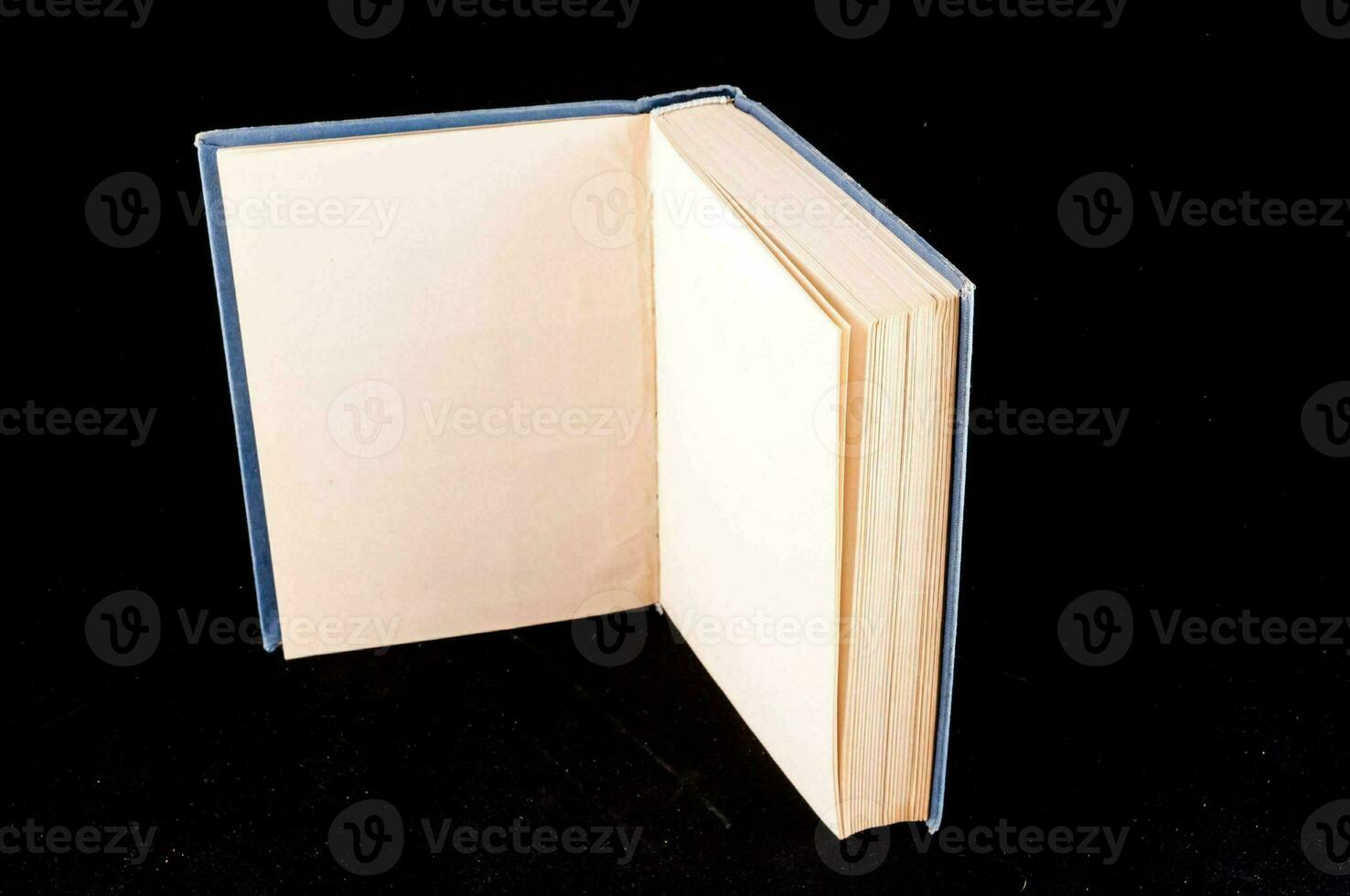 un Aperto libro con vuoto pagine su un' nero sfondo foto