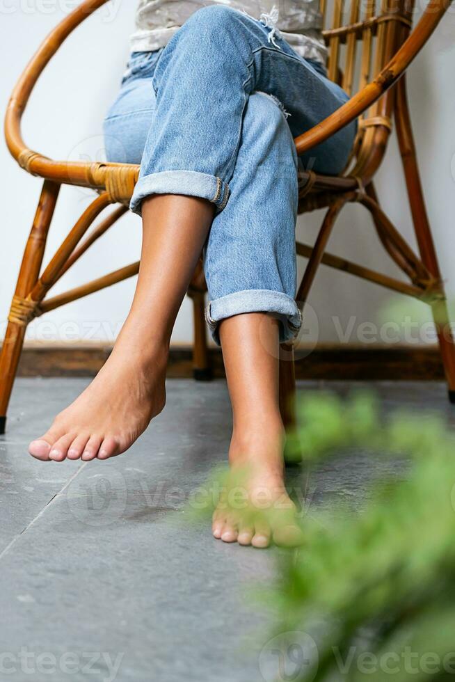 a piedi nudi donna rilassante nel comodo sedia su terrazza. foto